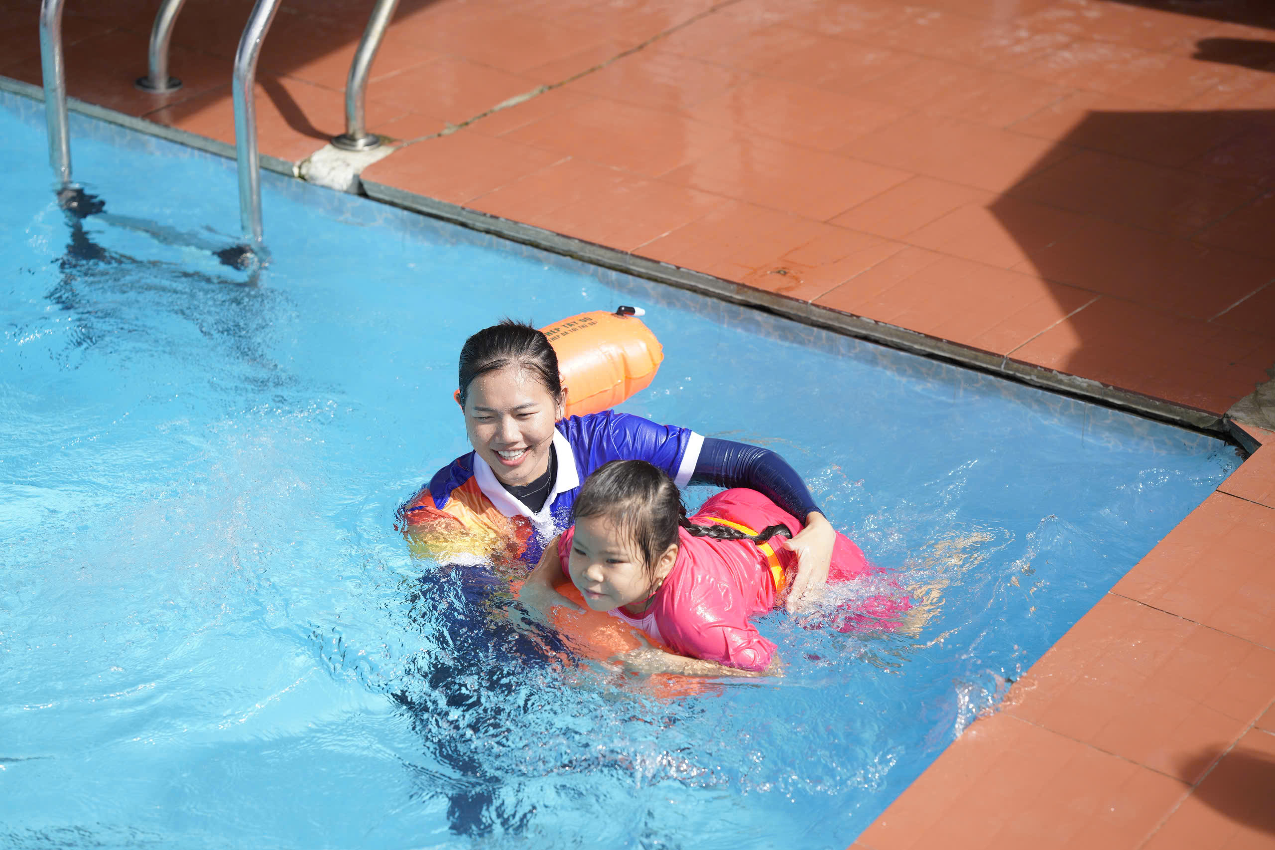 A person and a child in a pool  AI-generated content may be incorrect.